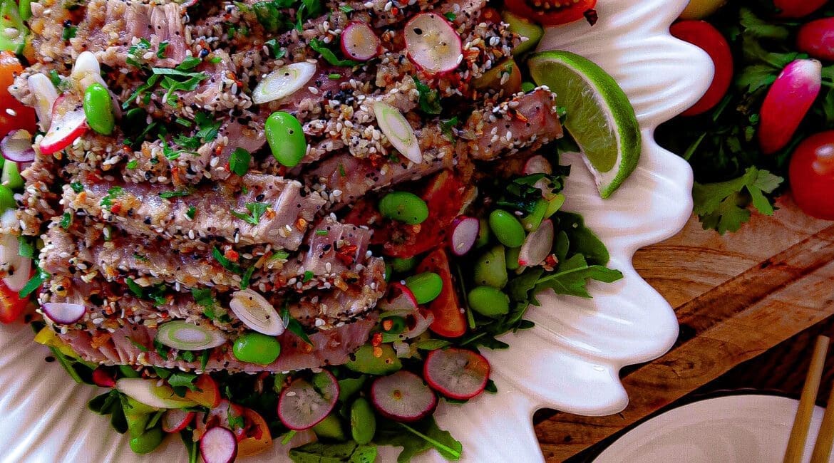 Asian-inspired sesame-crusted tuna with garlic ginger dressing and summer vegetables