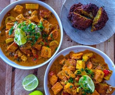 Bowl of creamy chicken and tofu tikka masala served with crispy onion bhajis and brown rice