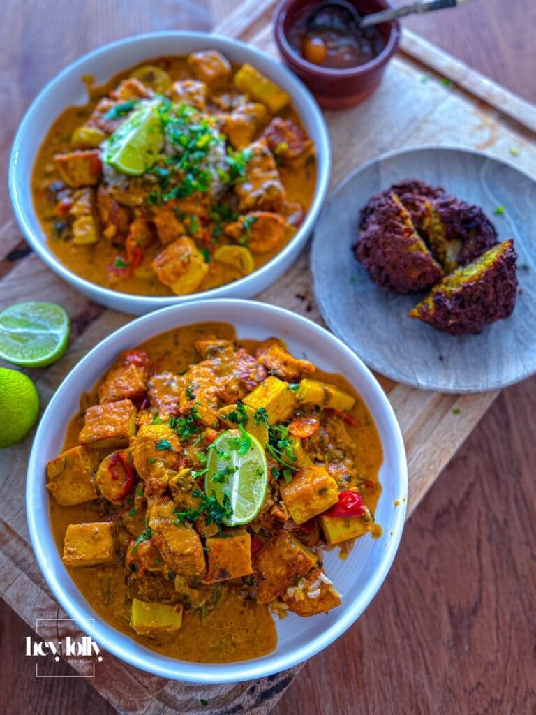 Bowl of creamy chicken and tofu tikka masala served with crispy onion bhajis and brown rice