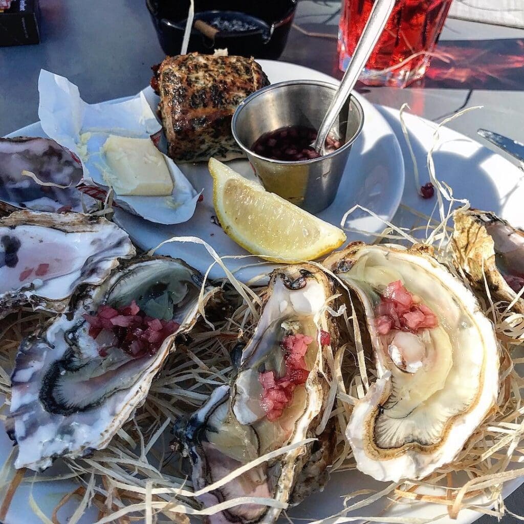 Oysters with citrus and bold sauces, examples of how travel influences cooking through unexpected flavour pairings.