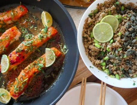 Glazed salmon fillet atop garlic-ginger quinoa pilaf with miso-glazed corn and fresh herbs.