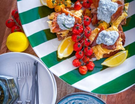 Scandi-style breakfast with eggs, mackerel, tomatoes, and crème fraîche on sourdough.