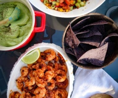 Seared prawns with avocado cream and summer salsa on table to share