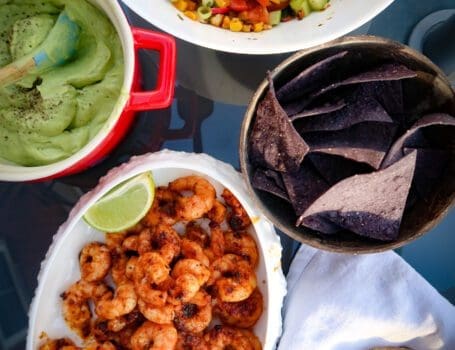 Seared prawns with avocado cream and summer salsa on table to share