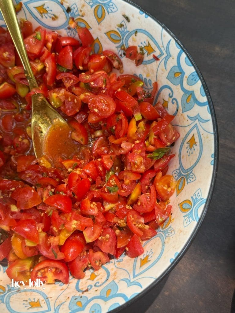 Bowl of chopped cherry tomatoes with olive oil and basil, part of the farm-to-table experience in Syracuse Sicily.