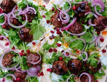Harissa lamb meatballs glazed with pomegranate molasses on flatbread