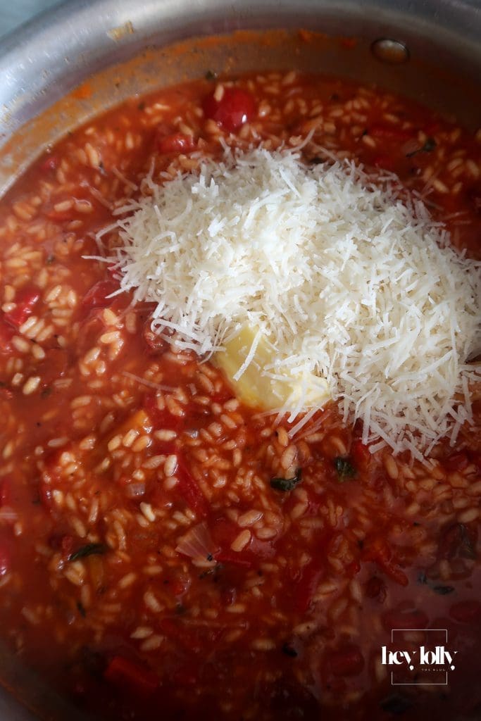 Close-up of creamy risotto bubbling in the pan with tomatoes and Parmesan