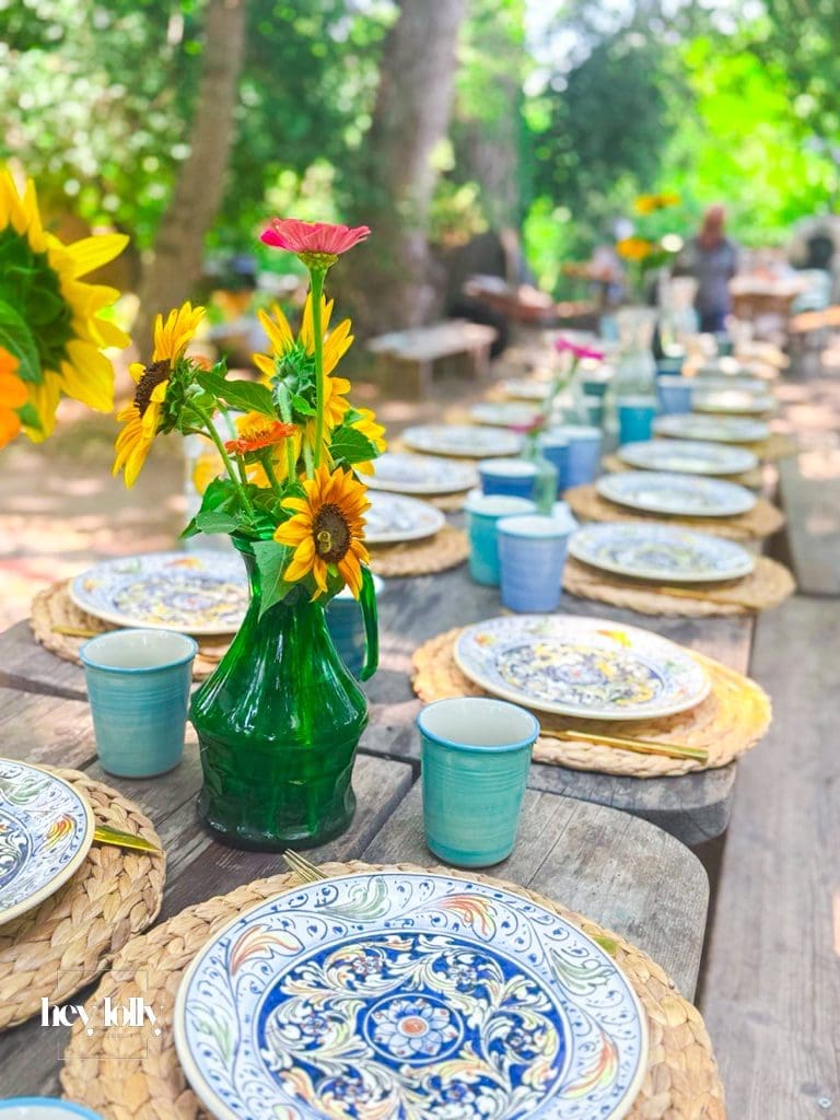 Long outdoor table set for 20 guests during the garden-to-table cooking class in Syracuse Sicily.