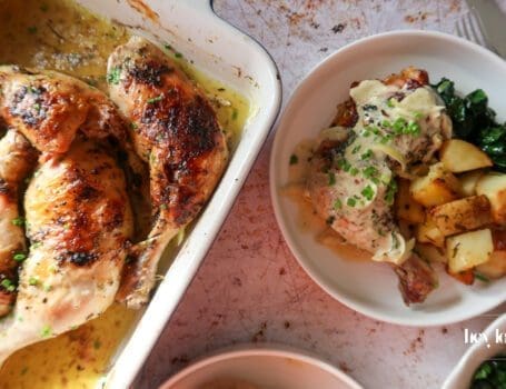 overhead shot of plated garlic roast butter chicken with lemon cavolo nero