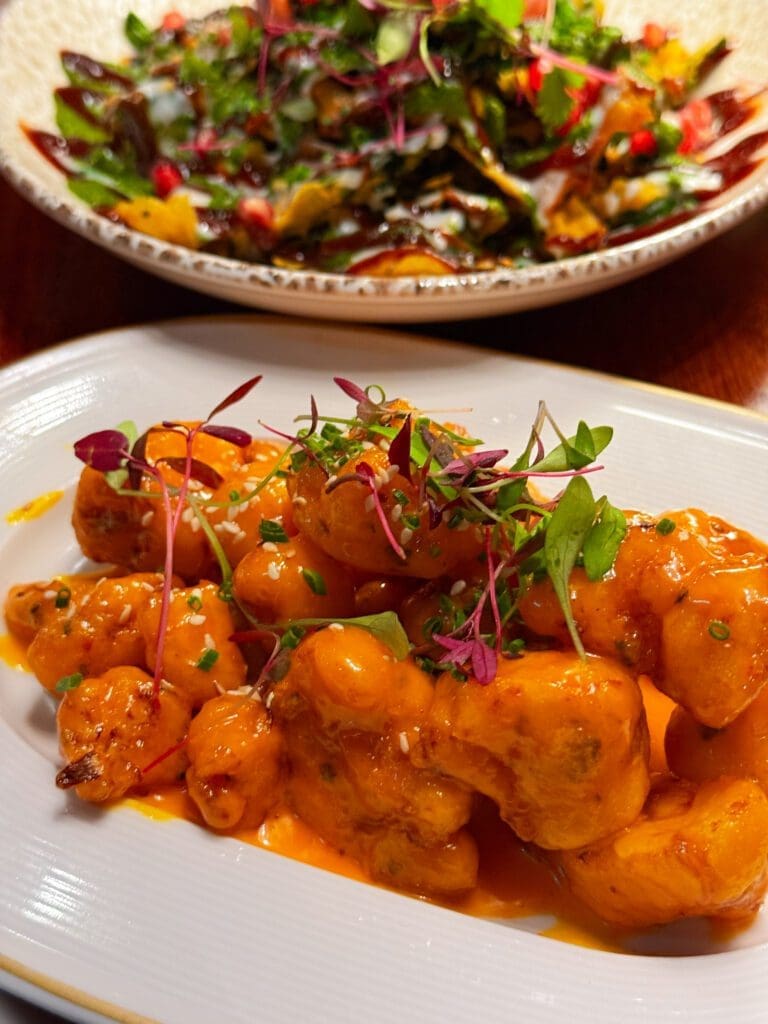 Bang Bang Cauliflower at Passan’s Nottingham — sticky, spicy florets coated in a glossy sauce with fresh herbs.