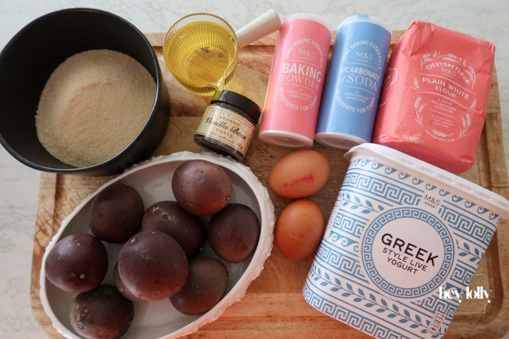 Ingredients for passion fruit yoghurt loaf laid out on kitchen counter — flour, eggs, yoghurt, passion fruits, sugar, and vanilla.