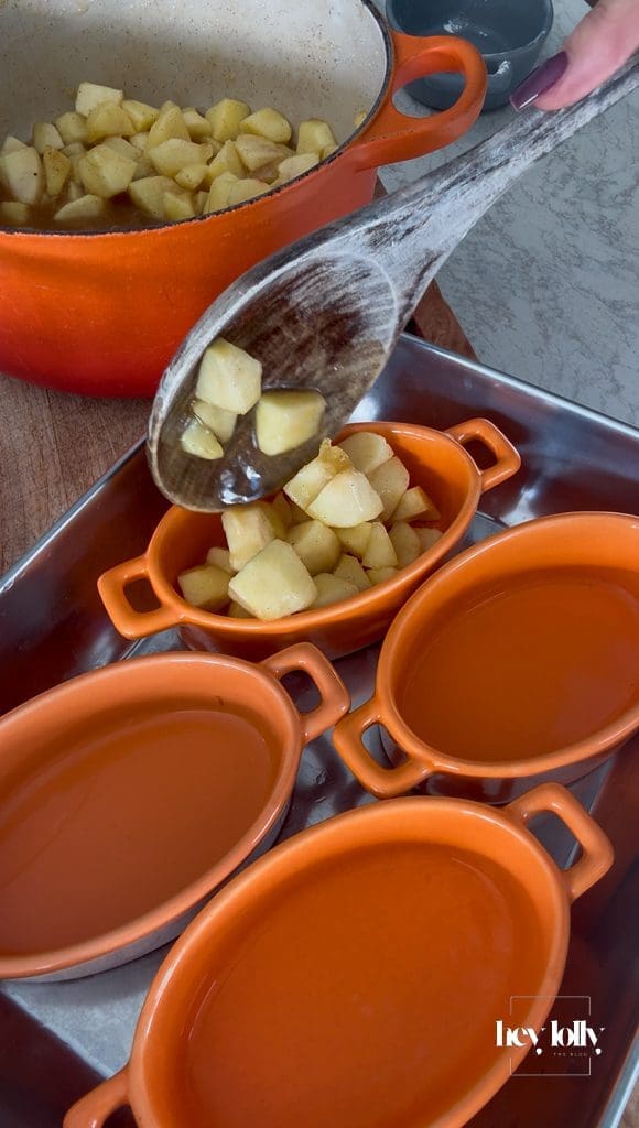 Warm cinnamon apples divided into four ramekins for apple and miso caramel crumble.