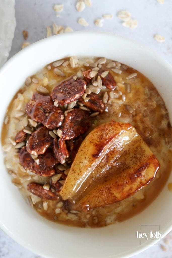 Porridge bowl topped with caramelised pears, pecans, and miso-maple drizzle – Maple-pear & pecan porridge with miso-maple swirl — cosy autumn breakfast bowl.