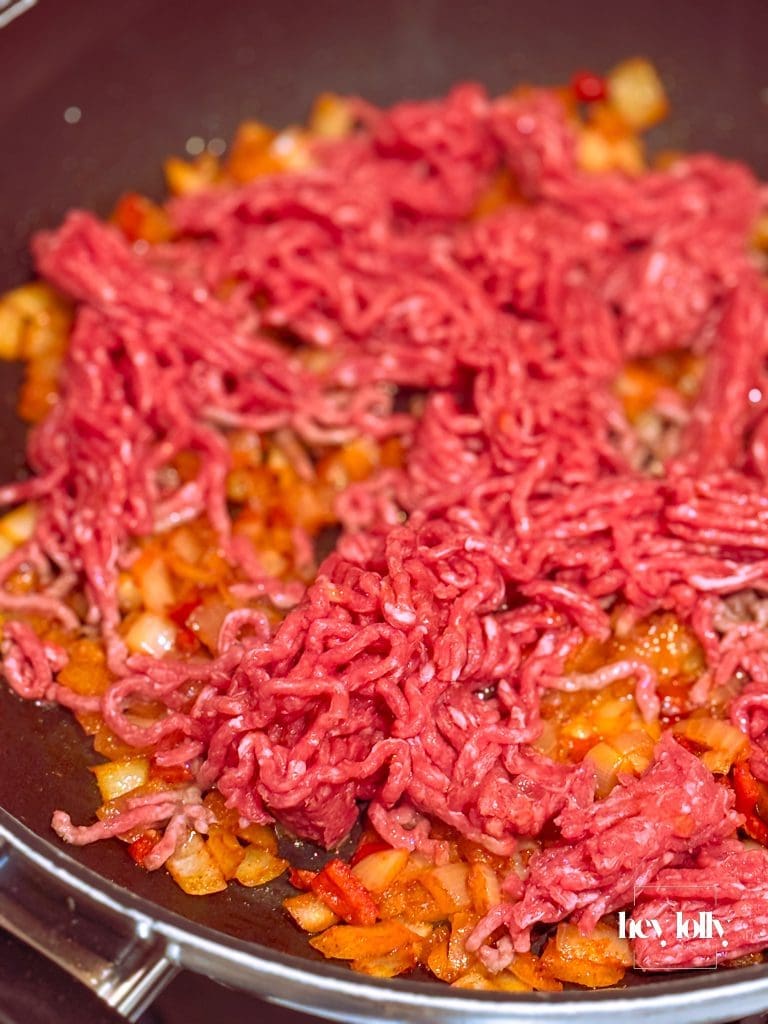 Beef mince browning deeply in the pan—caramelised bits visible.