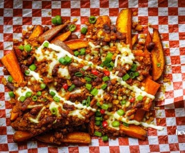loaded sweet potato fries with sour cream and herbs, ready to share.