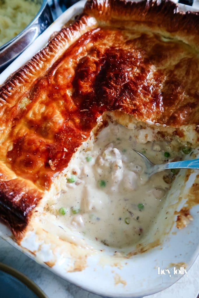 Chicken, pea and pancetta pie with golden puff-pastry lid in dish