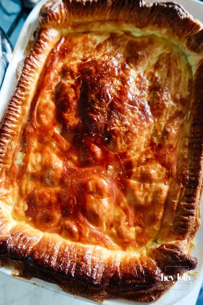 Overhead: crimping a puff-pastry lid on a deep-dish chicken pie