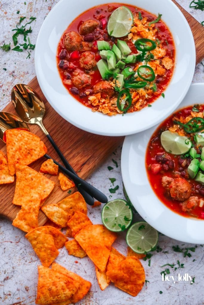Overhead bowl of Cowboy Taco Soup with beans, corn and peppers, finished with sour cream and lime