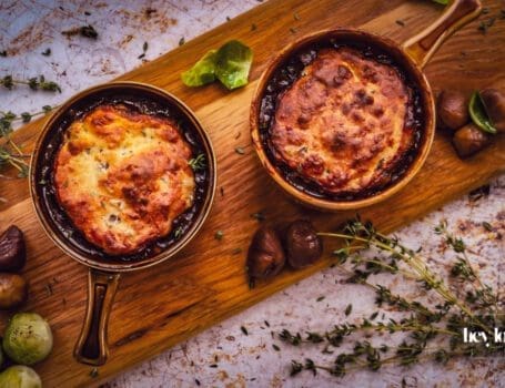 overhead shot of bubbling pots of herby chesnut and cheddar beef cobbler