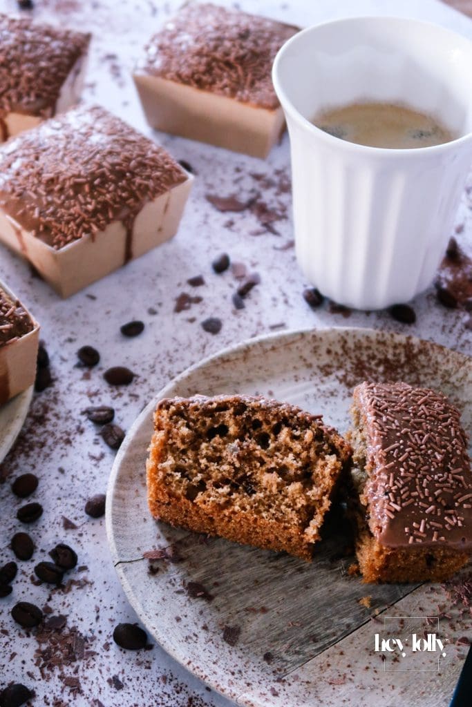 Slice of pecan and coffee cake on a plate, showing the tender crumb and shiny mocha glaze with pecan topping.
