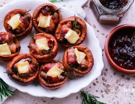 Pigs in blankets Yorkshire puddings with Brie and caramelised onion, festive platter scene.