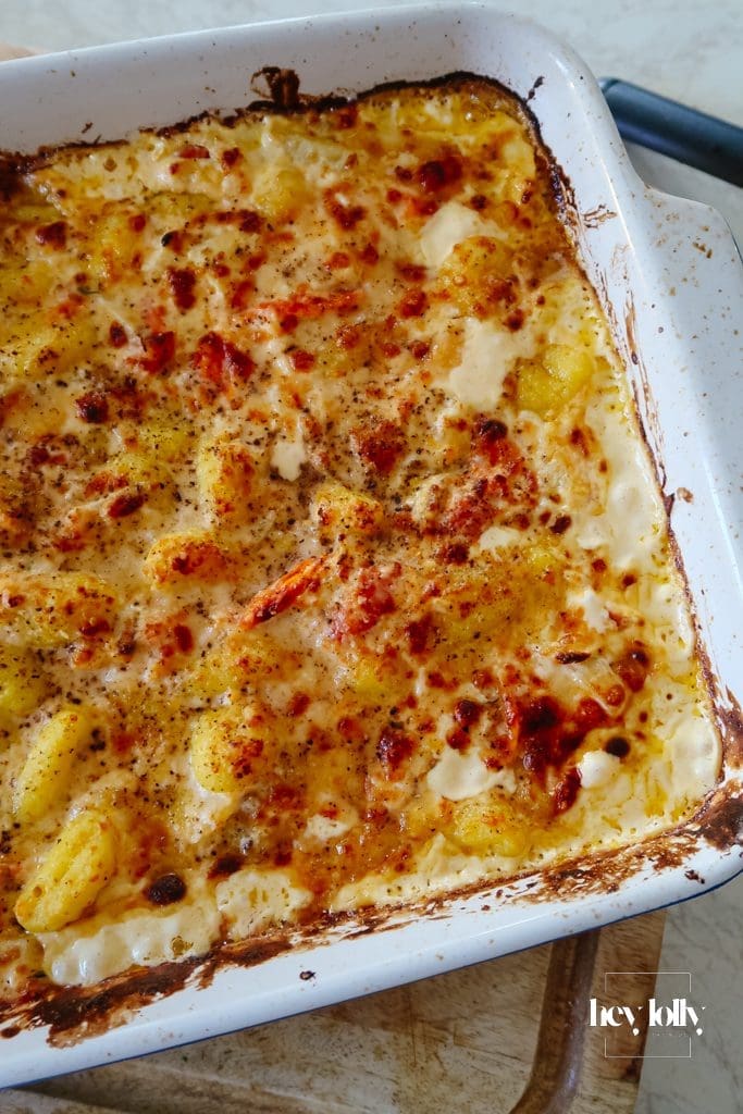 One-pot salmon and fennel gnocchi bake in an oven dish with golden Parmesan topping and burst cherry tomatoes