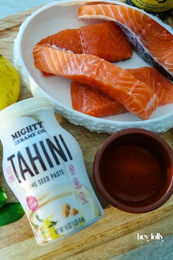 Ingredients for Salmon, Courgette & Halloumi Skewers with Lemon Tahini Dressing arranged on a board, ready to prep.