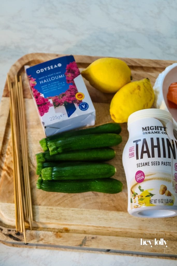 Ingredients for Salmon, Courgette & Halloumi Skewers with Lemon Tahini Dressing arranged on a board, ready to prep.