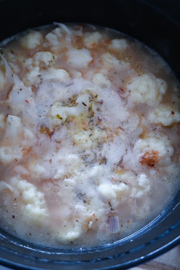 Cauliflower and white beans simmering in stock for cauliflower and white bean soup