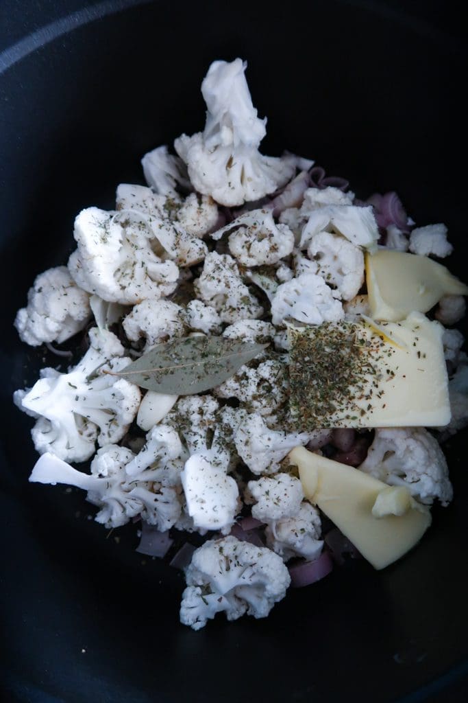 Onion sautéing in a pan for cauliflower and white bean soup