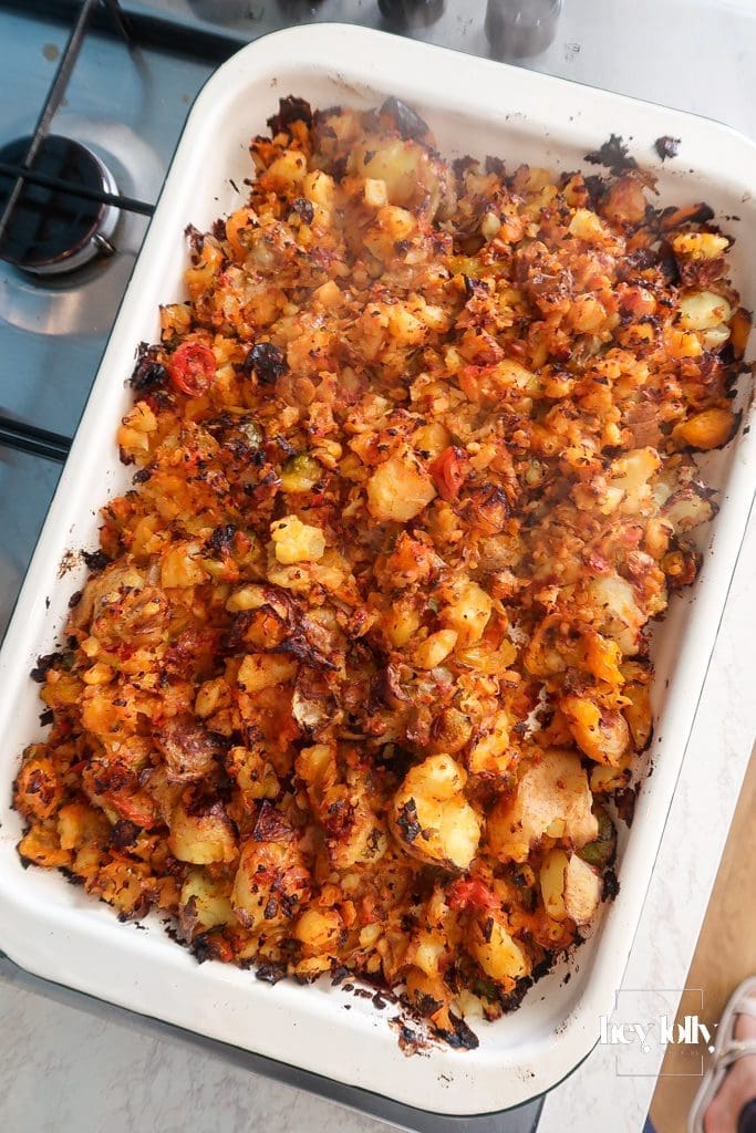 Potatoes crisping in an enamel tray for sprout and harissa potato hash