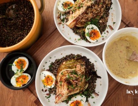 Overhead view of warm mustard lentils with charred cabbage, jammy eggs and garlic breadcrumbs in a shallow bowl