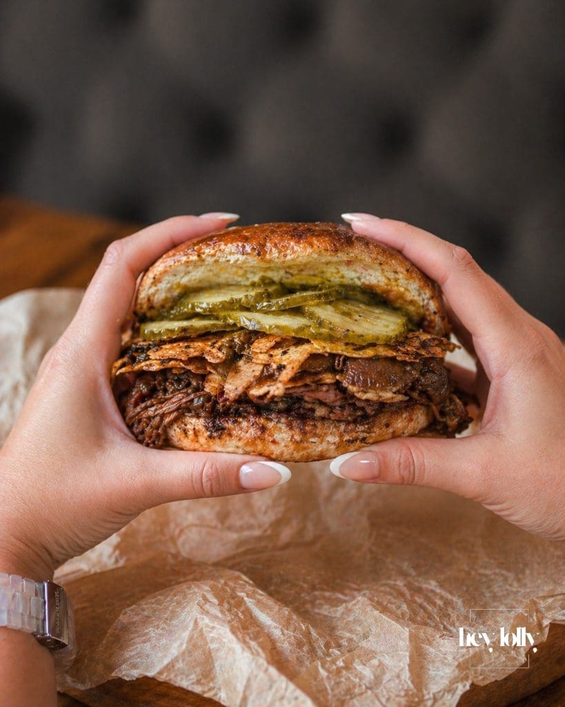 Maczanka krakowska sandwich from Andrus in Krakow held in two hands