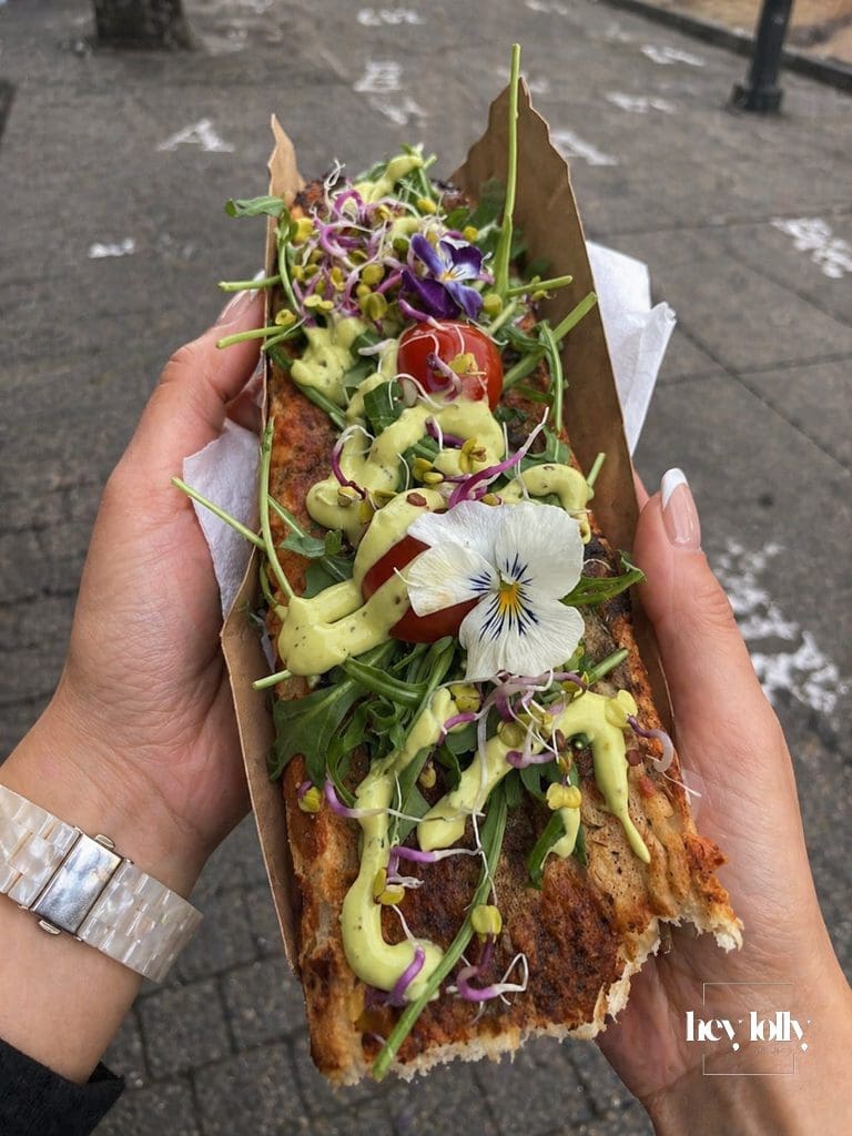 Loaded zapiekanki in Krakow with green sauce edible flowers and salad