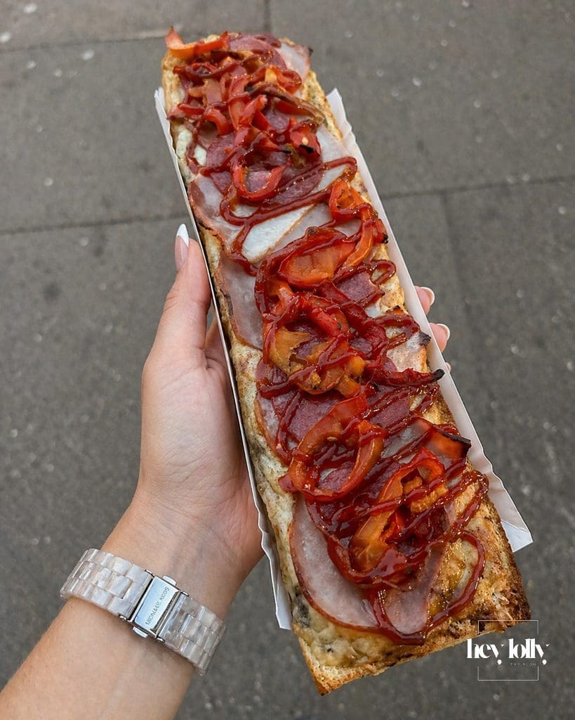 Zapiekanki in Krakow topped with ham peppers and red sauce