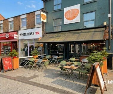 Exterior of Bistro 66 on High Road in Beeston with large front windows and outdoor seating