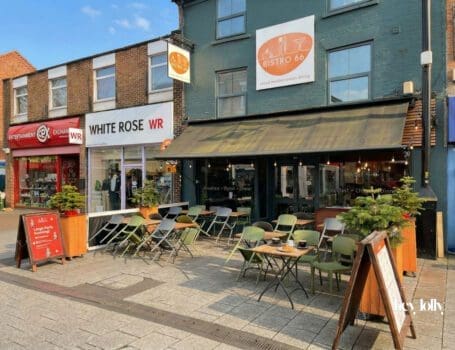 Exterior of Bistro 66 on High Road in Beeston with large front windows and outdoor seating
