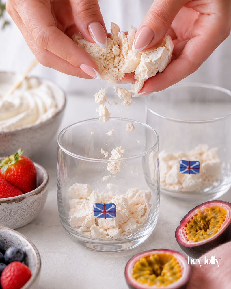 Crushed meringue, berries, passion fruit and whipped cream arranged for making summer pavlova cups.
